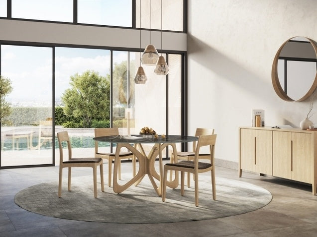 Modern dining room with a glass table and wooden chairs near large windows