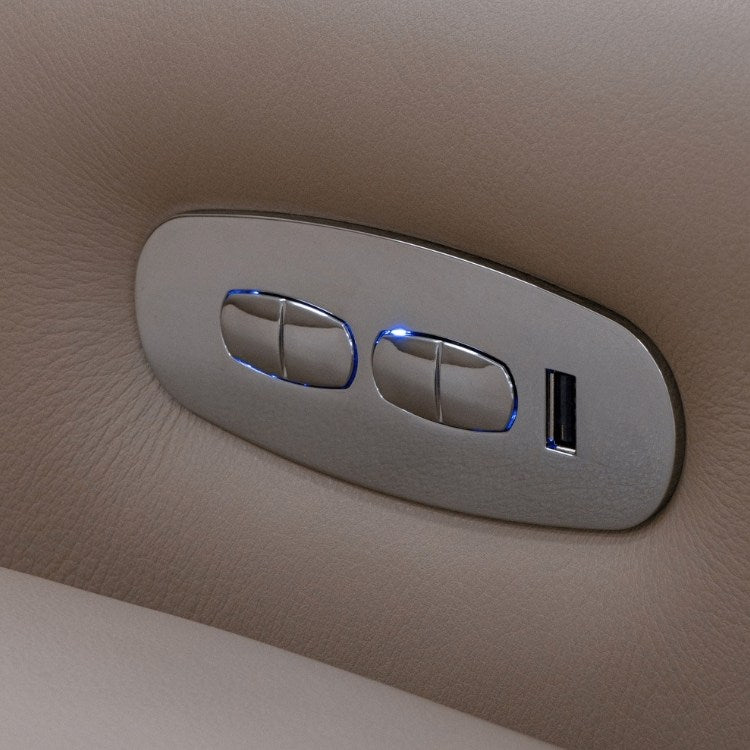 Close-up of a metallic control buttons and USB port on beige leather sofa