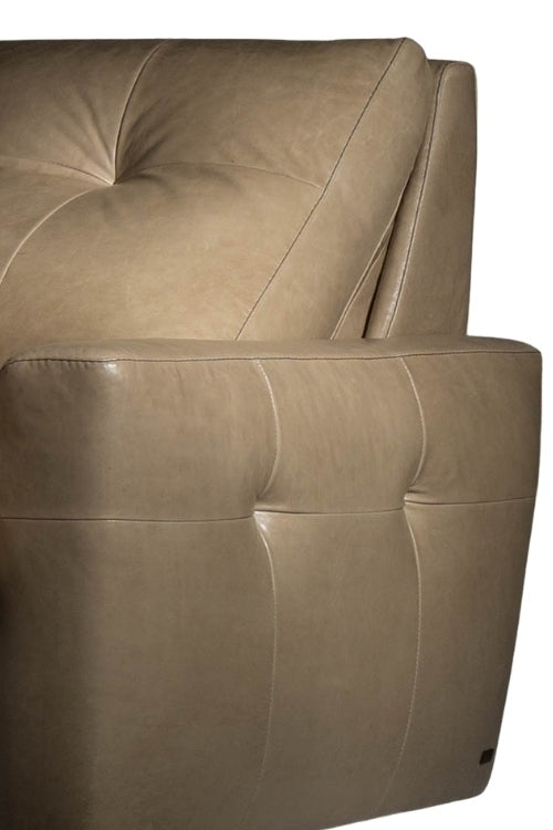 Close-up of a beige leather armchair with tufted backrest