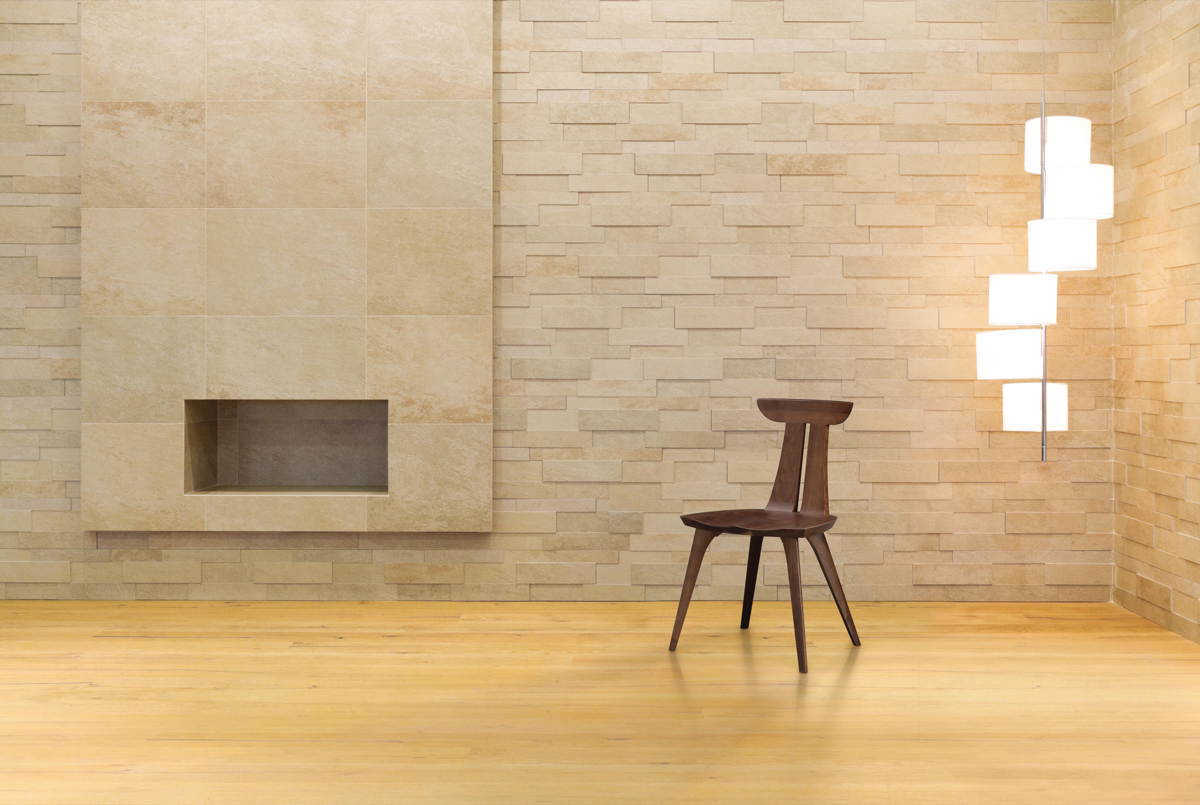Estelle Dining Chair in walnut in modern space with brick wall, floating lamp, and open fireplace