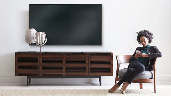 Woman reading by a TV Cabinet