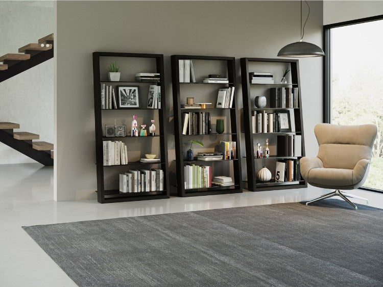 Eileen 5166 Leaning Shelf in Charcoal, 3 shelving systems with books and decor in room with seating and rug.