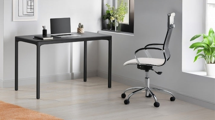 Luma Small Stationary Desk in black in decorated room with chair, laptop, and books.