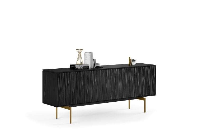 Modern white sideboard with wavy texture look with stainless steel legs and books and other decorative items on top. 