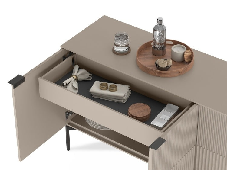 Beige sideboard with open drawer displaying kitchen items on a white background