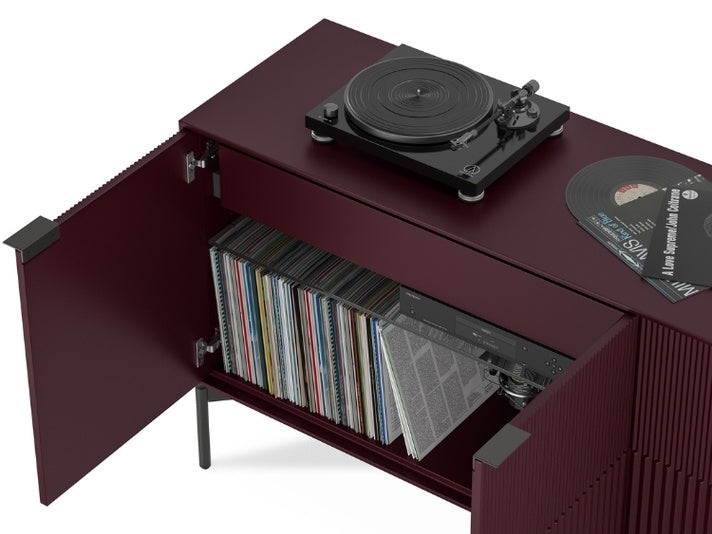 Turntable on a wooden cabinet with open door displaying records