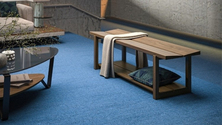 KAVA bench in walnut lifestyle with blanket and pillow, in decorated room with cocktail table and seating