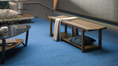 KAVA bench in walnut lifestyle with blanket and pillow, in decorated room with cocktail table and seating