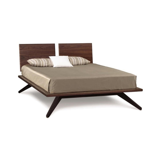 Wooden bed with beige bedding and striped pillows on a white background