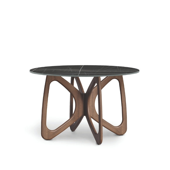 A round dining table with a dark stone top and a brown wooden sculptural base, designed in a contemporary style