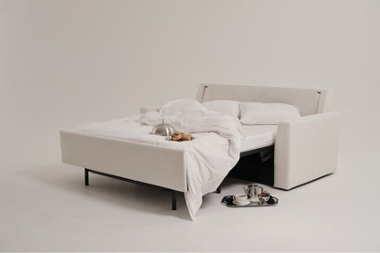 White sofa bed with a tray of tea and cookies on a white background