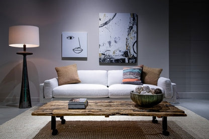 Cooks Elements Sofa high leg in white in decorated room with pillows, lamp, and coffee table.