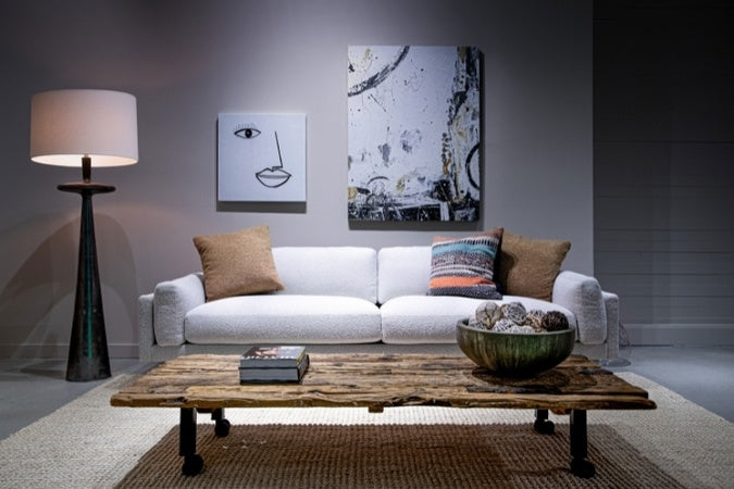 Cooks Elements Sofa high leg in white in decorated room with pillows, lamp, and coffee table.