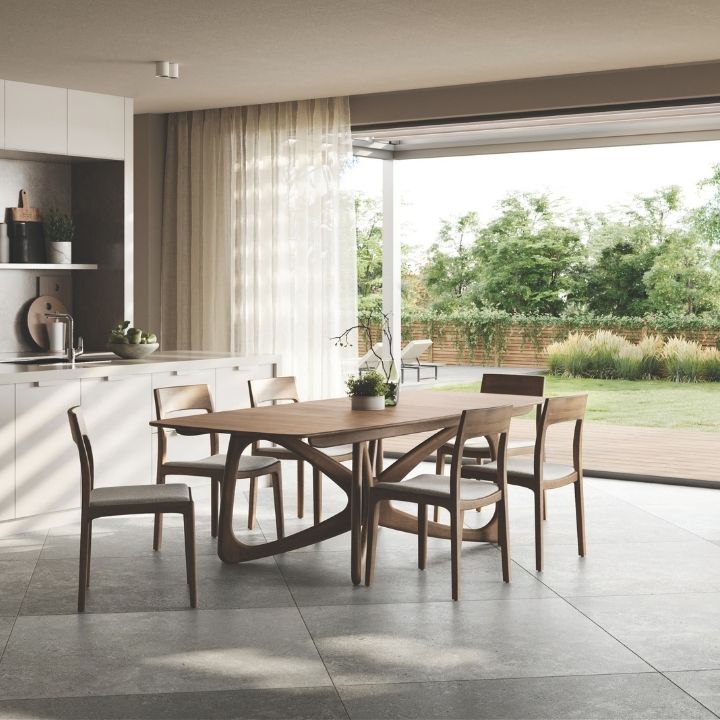 Modern kitchen with Copeland Butterfly wooden dining table and chairs, large window, and outdoor view.