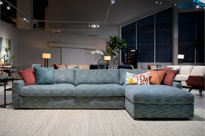 Gray sectional sofa with colorful pillows in a modern living room setting.