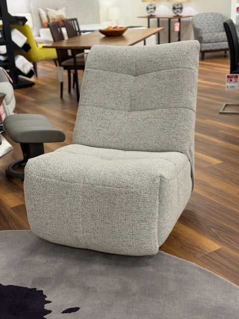 Gray chair in a room with wooden flooring and furniture.