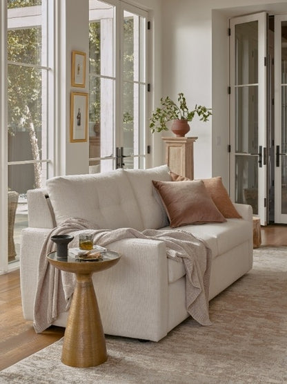 Beige sofa with a small table and decorative items in a bright living room.