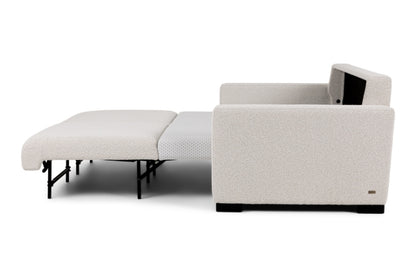 Side view of Beige sectional sofa bed pulled out to full size showing white mattress. 