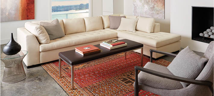Modern living room with beige sectional sofa, coffee table, and decorative items.
