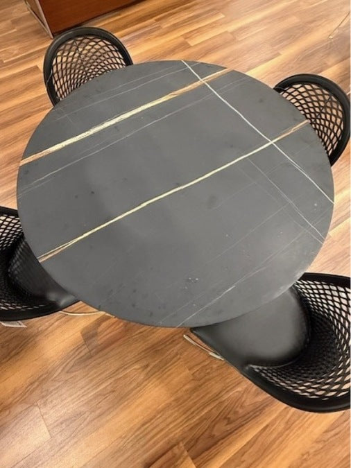 Top view of Flute Dining Table by Stone International is featured in Sahara Noir stone finish