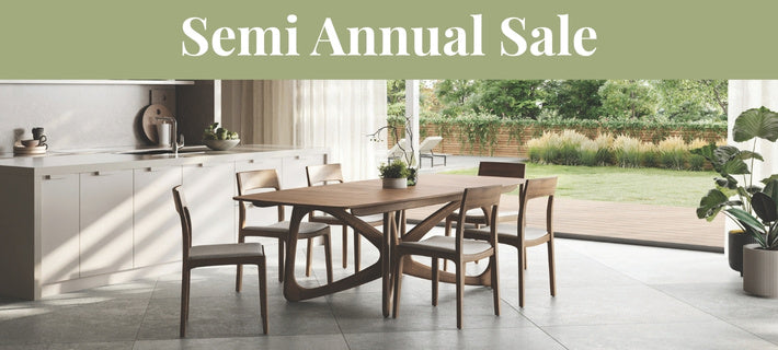 A dining room scene with a Copeland solide wood dining table and chairs, set in a modern kitchen with large windows overlooking a green garden. A green banner at the top reads 'Semi Annual Sale'.