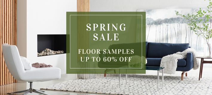 Living room with a 'Spring Sale' sign for floor samples.