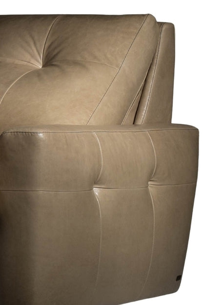 Close-up of a beige leather armchair with tufted backrest