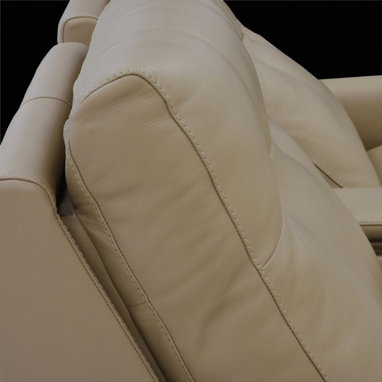 Close-up of beige leather theater seating showing pillow area for headrest 