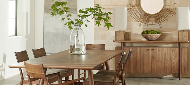 Dining room with wooden table and chairs, decorative vase, and wall mirror.