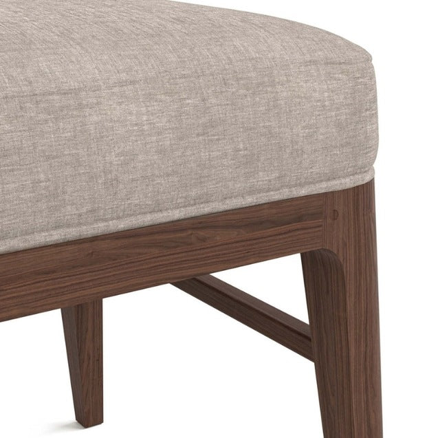 Close-up of a chair with a gray cushion and wooden frame 