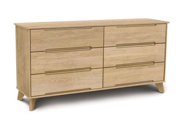 Oak wooden six drawer dresser with angled legs and recessed handles in mid century modern style.