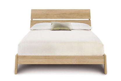Linn Oak Platform Bed with slatted headboard,  and angled legs. 