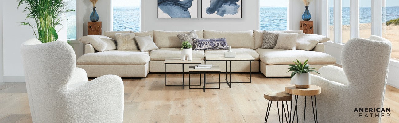 Modern living room with a large beige sectional sofa, coffee table, and decorative items.
