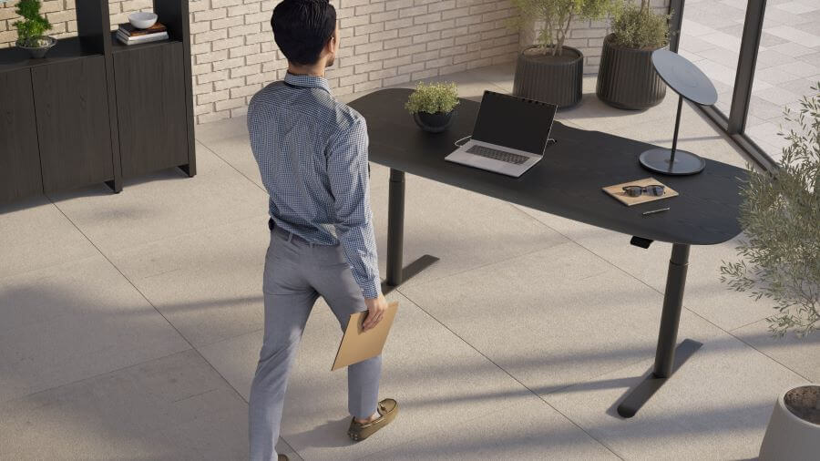 Soma 6352 Lift Desk in Ebonized Ash with laptop and man walking towards it