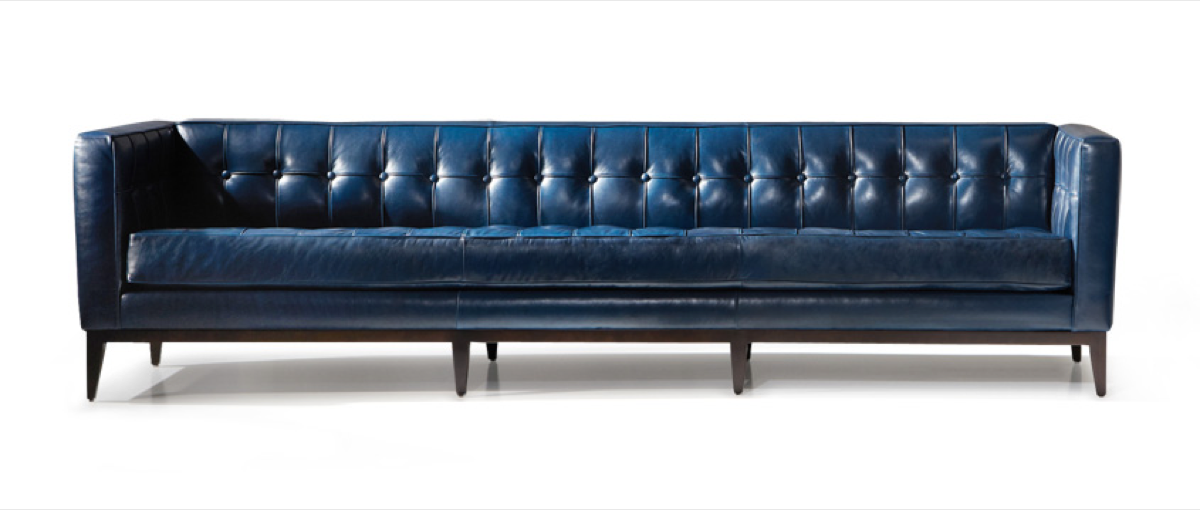 Gorgeous and Glamerous modern sofa boasts an Art Deco feel with a low-profile and tufted back, which is contrasted by a solid wood base in navy blue.