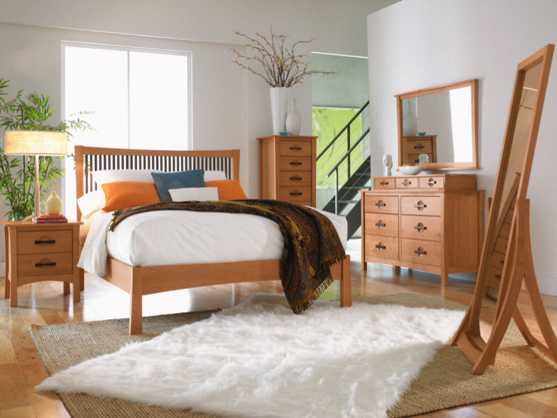 Berkeley Bed in cherry in decorated bedroom with nightstand, dressers, mirrors, and layered rugs.