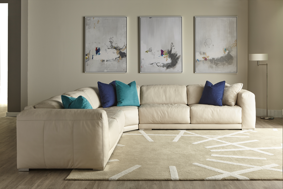 Malibu Sectional beige color with navy and teal pillows. 