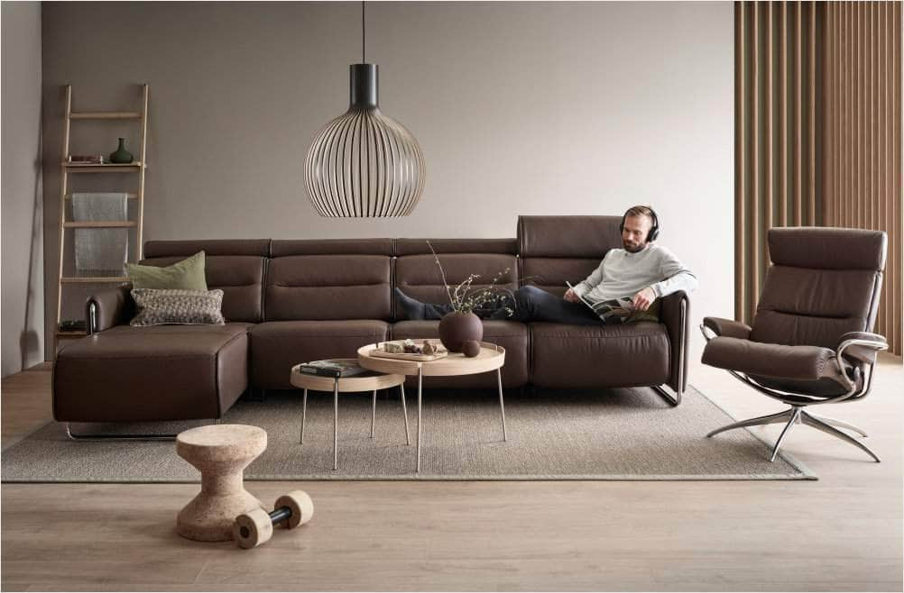 Stressless Emily 3 Seat Reclining Sofa in decorated room with man sitting and reading