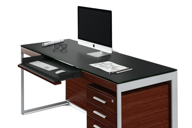 Setup view of the Sequel 20 6101 Desk by BDI Furniture in Chocolate Stained Walnut finish with a computer and glasses.