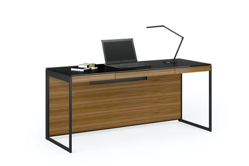 Front view of the Sequel 20 6101 Desk by BDI Furniture in Natural Walnut finish with a Laptop, books, and desklamp.