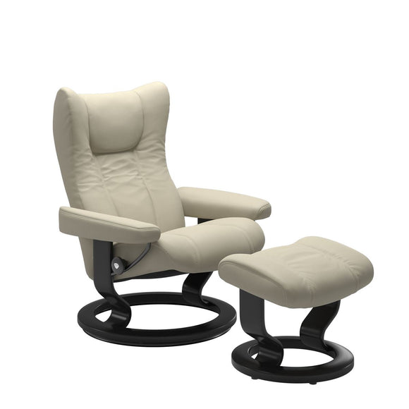 Modern reclining chair with matching ottoman, featuring light grey upholstery, and classic round wooden base in black with padded armrest. 