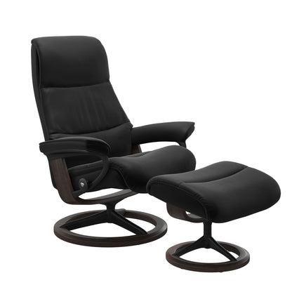 View recliner in Paloma Black with matching ottoman featuring a curved base in metal and wenge