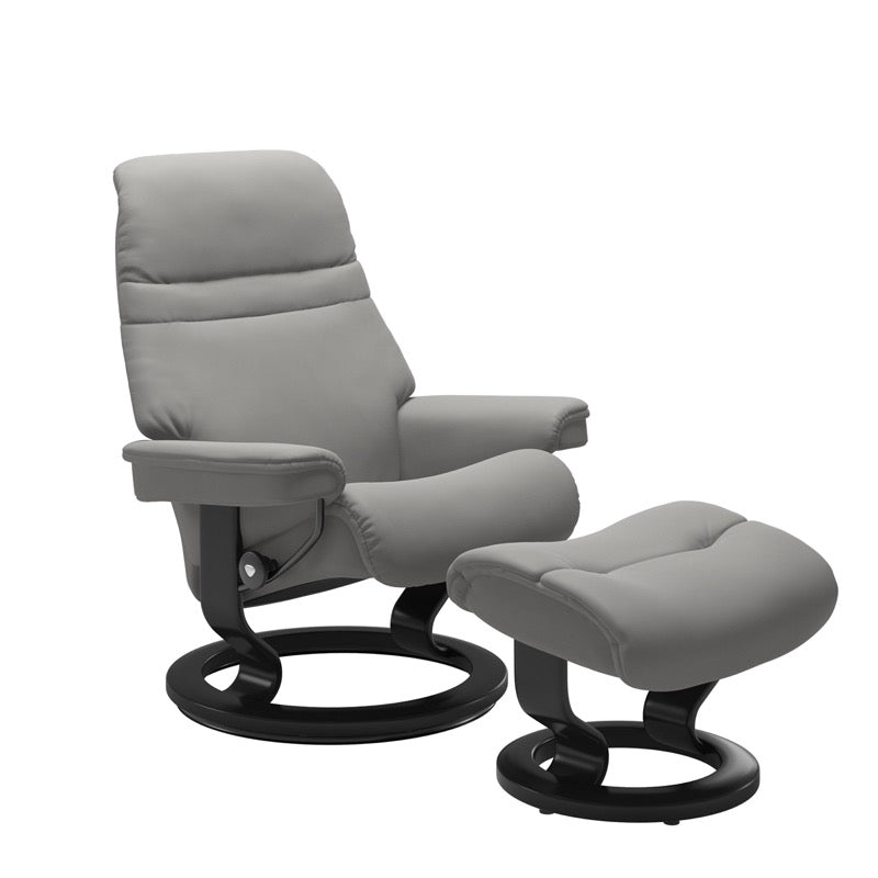 Silver grey colored sunrise recliner with matching ottoman both featuring a circular base in black wood. 