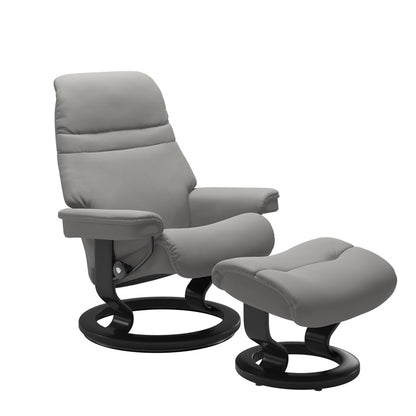 Silver grey colored sunrise recliner with matching ottoman both featuring a circular base in black wood 