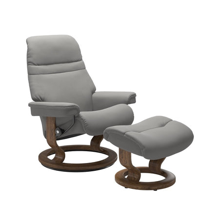Silver grey colored sunrise recliner with matching ottoman both featuring a circular base in teak wood. 