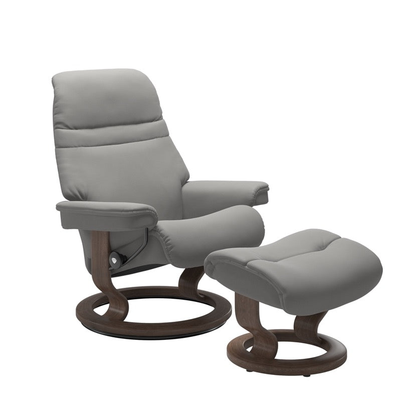 Silver grey colored sunrise recliner with matching ottoman both featuring a circular base in walnut wood 