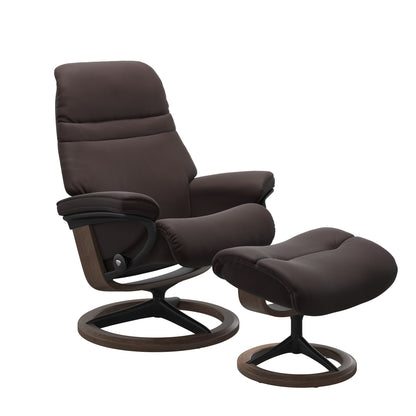 Chocolate colored sunrise recliner with matching ottoman featuring a curved base in metal and walnut