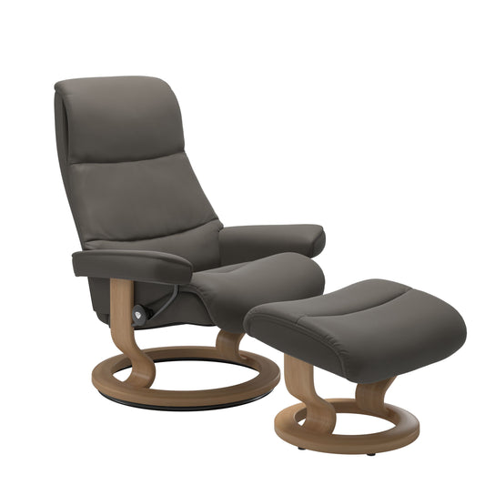 Recliner with matching ottoman in metal gray with classic round wooden base in oak with padded armrest. 